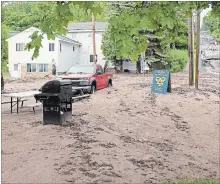  ?? DAVID ARCHAMBEAU THE ASSOCIATED PRESS ?? Widespread flooding in the Upper Midwest was blamed for at least one death in Wisconsin. Here, mud and debris fill a Houghton, Mich., street.