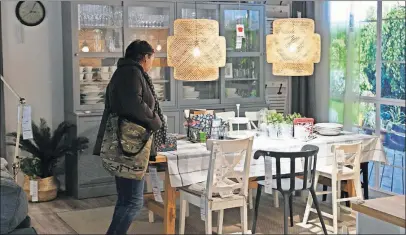  ?? [ALIK KEPLICZ/THE ASSOCIATED PRESS] ?? A customer looks at furniture in a new Ikea store in downtown Warsaw, Poland. The centrally located store is 54,000 square feet, a quarter the size of most big-box stores.