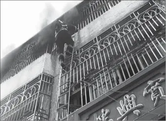  ?? PROVIDED TO CHINA DAILY ?? A firefighte­r climbs up a burning building of an underwear factory in Shantou, Guangdong province on Tuesday. Fourteen people were killed. Liu Shuangyun, a man suspected of starting the fire, was arrested.