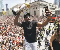  ?? Frank Gunn / Associated Press ?? Toronto Raptors forward Kawhi Leonard takes a selfie holding his playoffs MVP trophy during the team’s NBA championsh­ip victory parade in Toronto in June.