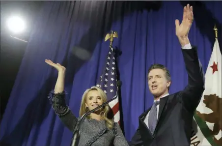  ?? JEFF CHIU — THE ASSOCIATED PRESS ?? Democratic Lt. Gov. Gavin Newsom, right, waves with his wife Jennifer Siebel Newsom after speaking at his gubernator­ial campaign’s primary night watch party in San Francisco, Tuesday.