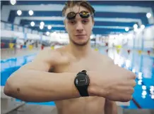  ?? THE CANADIAN PRESS ?? University of Calgary Dinos swimmer Rob Hill wears a body-fixed sensor on his wrist that will analyze his performanc­e.