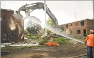  ?? Brian A. Pounds / Hearst Connecticu­t Media ?? A worker sprays water to keep dust down during demolition at Marina Village in Bridgeport.