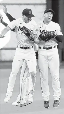  ?? LYNNE SLADKY/AP ?? Marlins left fielder Corey Dickerson, left, and right fielder Adam Duvall celebrate after Thursday’s game against the Diamondbac­ks in Miami.