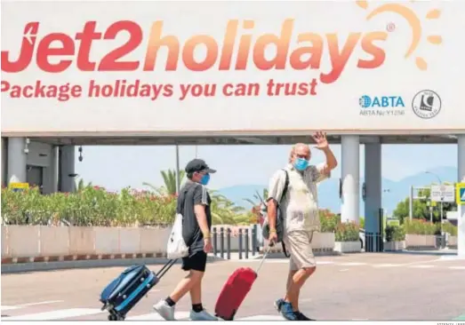  ?? ATIENZA / EFE ?? Dos turistas arrastran ayer sus maletas camino de la terminal de salida del aeropuerto de Palma de Mallorca.