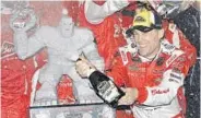  ?? NICK WASS/ASSOCIATED PRESS ?? Kevin Harvick sprays the “Miles the Monster” trophy with champagne following his Sunday evening victory at Dover.