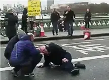  ??  ?? Terrifying
encounter: A video grab obtained from Polish politician Radoslaw Sikorski, showing a man on the ground receiving assistance on Westminste­r Bridge.