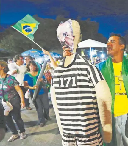  ??  ?? ► Un opositor a Lula protesta con un muñeco con la imagen del petista ayer, en Brasilia.