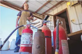  ?? GINO GUTIERREZ/JOURNAL ?? Vince Mora explains how he uses old fire extinguish­ers to make some of his art at his home.