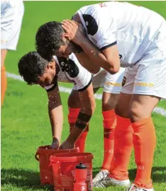  ?? Foto: Andreas Lode ?? Tropische Temperatur­en ließen die Fußballer kräftig schwitzen. Die Neusässer Spie ler Yunus Özkan und Akif Dogan erfrischen sich mit kaltem Wasser.