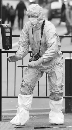  ??  ?? A forensic investigat­or recovers a knife after man was arrested on Whitehall in Westminste­r, central London. — Reuters photo