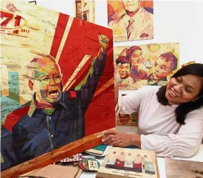  ??  ?? Vibrant art: Cetakayu marketing officer Estu Awastasia holding a portrait of Najib printed on wood at her booth at PWTC.