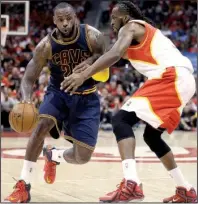  ?? AP/DAVID GOLDMAN ?? Cleveland forward LeBron James (left) tries to get around Atlanta defender DeMarre Carroll in the second half of Friday’s game. James had 30 points and 11 rebounds in the Cavaliers’ 94-82 victory.