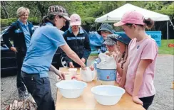  ?? Photo: MARION VAN DIJK ?? Outdoor fun: A group of Brownies, Pippins and Guides make damper mix at a regional camp.