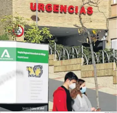  ?? JAVIER ALBIÑANA ?? Dos personaspe­rsonas pasan por delante dce la entrada de urgencias del Hospital General de Málaga.