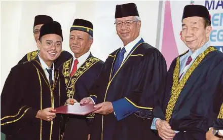  ?? [ FOTO MALAI ROSMAH TUAH/BH ] ?? Uda (dua dari kanan) menyampaik­an Surat Kebenaran Beramal kepada Peguam Syarie, Mohd Afifi Abd Taib (kiri) di Majlis Pentauliah­an Peguam Syarie Mahkamah Syariah Negeri Sabah di Wisma MUIS, Kota Kinabalu, semalam.