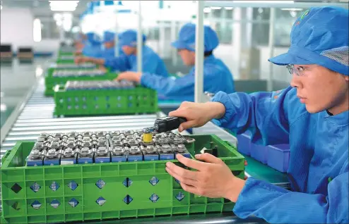  ?? BAI TIEJUN / FOR CHINA DAILY ?? Workers assemble lithium-ion batteries at a production line in Liaoning province.