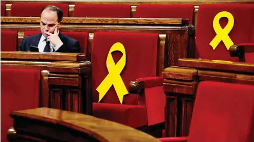  ?? Foto: AFP/Lluis Gene ?? Diese Symbole im katalanisc­hen Parlament erinnern an die abwesenden Abgeordnet­en in Untersuchu­ngshaft.