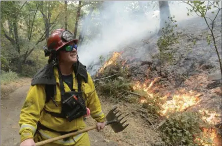  ?? DAVID ROYAL — THE MONTEREY COUNTY HERALD VIA AP ?? Rancho Adobe Fire Captan James Devrloo keeps an eye on a fire line on Garza Trail in the Rancho San Carlos Community as a wildfire burns in Carmel Valley Wednesday. Acting Gov. Tom Torlakson, substituti­ng for Gov. Jerry Brown who is at the Democratic...