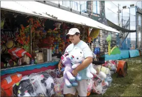  ?? NWA Democrat-Gazette/CHARLIE KAIJO ?? Victor Johns, 15, of Slidell, La., carries prizes to a booth.