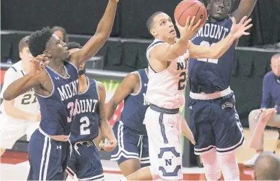  ?? KARL MERTON FERRON/THE CAPITAL ?? Navy guard Cam Davis powers to the hoop by driving past a group of Mount St. Mary’s defenders Saturday.