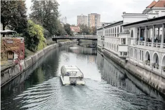  ?? Bloomberg ?? A sightseein­g boat travels along the Ljubljanic­a River in Ljubljana, Slovenia.