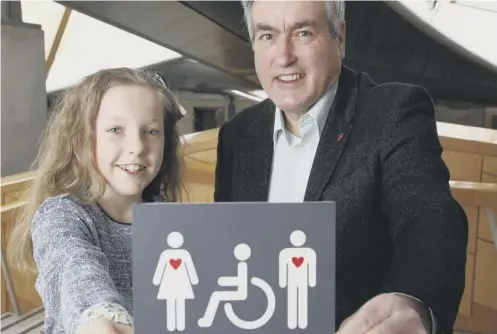  ??  ?? 0 Crohn’s disease sufferer Grace Warnock presents MSP Iain Gray with the disability symbol she helped design