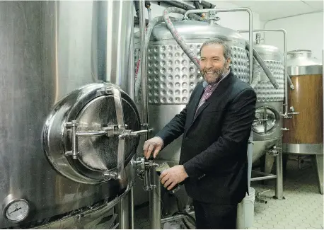  ?? NATHAN DENETTE/The Canadian Press ?? NDP Leader Tom Mulcair pours a pint of beer at a Toronto brew pub in February. We can expect to see him looking more like Everyman Tom and less
like Intellectu­al Tom on the campaign trail, writes Michael Den Tandt.