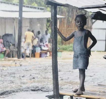  ??  ?? 0 A girl stands on the porch of her house in Pemba as Cyclone Kenneth hits northern Mozambique