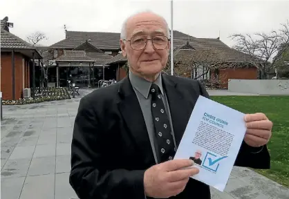  ?? PHOTO: MATTHEW SALMONS/FAIRFAX NZ ?? Council candidate Chris Gunn displays a larger version of his missing flyer.