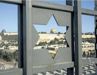  ?? ODED BALILTY/THE ASSOCIATED PRESS FILES ?? In this July 25 file photo, Jerusalem’s Old City is seen through a door with the shape of star of David.