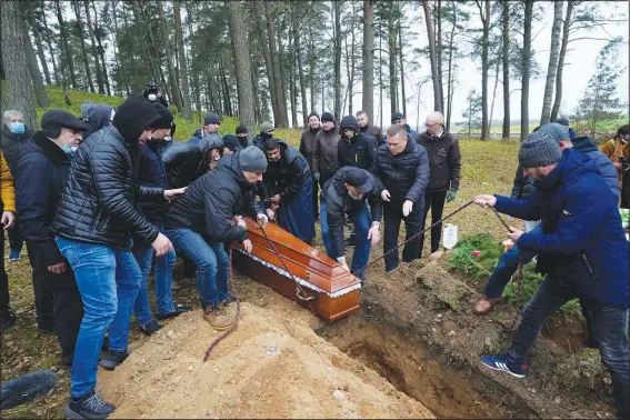  ?? (AP/Czarek Sokolowski) ?? A local Muslim community buries Yemeni migrant Mustafa Mohammed Murshed Al-Raimi on Sunday in Bohoniki, Poland. The migrant was one of about a dozen people from the Middle East and elsewhere who have died in an area of forests and bogs along the Poland-Belarus border amid a standoff involving migrants between the two countries. The burial took place in a Muslim cemetery in Bohoniki, where a population of Muslim Tatars has lived for centuries. It was the second funeral which community members have performed for a migrant in the past week.