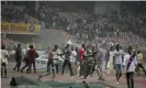  ?? Photograph: Sunday Alamba/AP ?? Police fire tear gas to try to remove Nigerian spectators from the pitch after Ghana qualified at Nigeria’s expense on away goals.