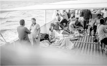  ??  ?? Migrants wait onboard the NGO Proactiva Open Arms boat after they were rescued trying to cross the Mediterran­ean from Libya.— AFP photo