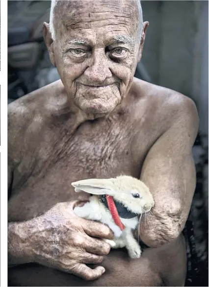  ??  ?? Rafael and his pet rabbit on the pavement in Santa Clara, Cuba.