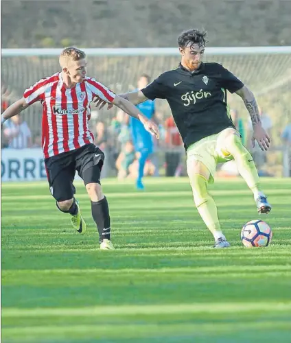  ?? FOTO: MIREYA LÓPEZ ?? Sobre el césped Amorebieta, en sus primeros minutos como jugador del Sporting, controla un balón ante la presión de Muniain