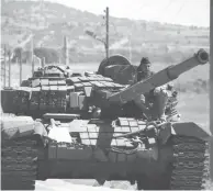  ??  ?? Des rebelles syriens conduisant un tank dans la province de Quneitra en Syrie