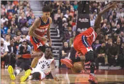  ?? The Canadian Press ?? Toronto Raptors forward DeMarre Carroll loses a fight for a loose ball against Washington Wizards forward Kelly Oubre Jr., left, and Ian Mahinmi during an NBA game in Toronto on Wednesday. The Wizards won 105-96.