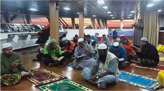  ??  ?? Brothers in faith The aid mission’s volunteers praying onboard the ship somewhere in the Andaman Sea.