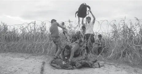  ?? ZOLTAN BALOGH/THE ASSOCIATED PRESS ?? People cross the border between Hungary and Serbia Wednesday. Hungary has become a flashpoint as Europe struggles to handle a torrent of migrants.