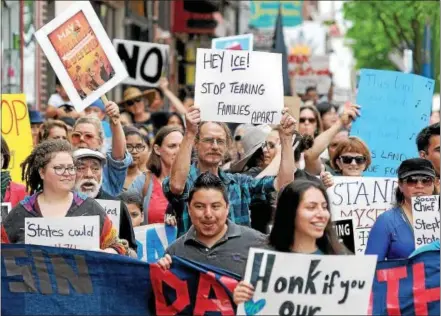 ?? GENE WALSH — DIGITAL FIRST MEDIA ?? Protesters march together along Bridge Street during “A Day Without Immigrants” Rally in Phoenixvil­le Monday.