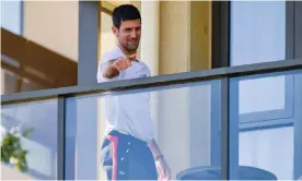  ??  ?? Novak Djokovic gestures on Monday from his hotel balcony in Adelaide, where he is in quarantine before the Australian Open. Photograph: Brenton Edwards/AFP/Getty Images