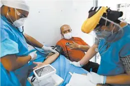  ?? REBECCA BLACKWELL/AP ?? Dr. Anahi Moreno, right, and Giovanni Barragan attend to a patient in a mobile health clinic Wednesday in Mexico City.