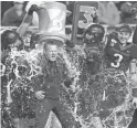  ?? USA TODAY SPORTS PHOTOS ?? Left: Huskies head coach Chris Peterson, left, holds up the Apple Cup after beating Washington State last month. Chris Petersen has led the Huskies to two Pac-12 titles and three New Year’s Six bowls, including a berth in the College Football Playoff in 2016. Right: Boise State players give head coach Bryan Harsin a Gatorade bath after they won the Mountain West Championsh­ip.