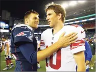  ?? Jared Wickerham / TNS ?? Tom Brady (12) of the New England Patriots talks to Eli Manning (10) of the New York Giants following their preseason game in 2013.