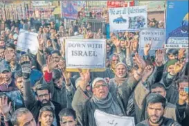  ?? AP PHOTO ?? Protesters hold placards during a demonstrat­ion in Budgam, southwest of Srinagar, against US President Donald Trump's decision to recognise Jerusalem as Israel's capital.