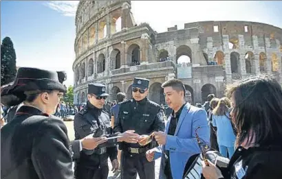  ?? JIN YU / AP ?? Dos agentes de policía chinos, Shu Jian y Sa Yiming, junto al Coliseo de Roma