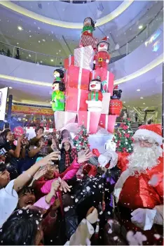  ??  ?? Santa Claus brings early Christmas cheers as kids revel in the artificial snowfall during the Dolly Christmas launch at SM City Marilao. The 20 ft snowy, dolly Christmas centerpiec­e serves as seasonal centerpiec­e in the mall’s busiest atrium. The centerpiec­e is Japanese inspired with modern recreation of the country’s traditiona­l folk-art called Kokeshi dolls.