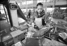  ?? WANG LIXIN / FOR CHINA DAILY ?? An employee working at an express logistics park in Guizhou province busily sorts parcels on Jan 26.