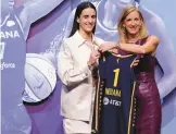  ?? ADAM HUNGER/AP ?? Caitlyn Clark, left, poses for photos with commission­er Cathy Engelbert after being selected No. 1 overall by the Fever at the WNBA draft on Monday.